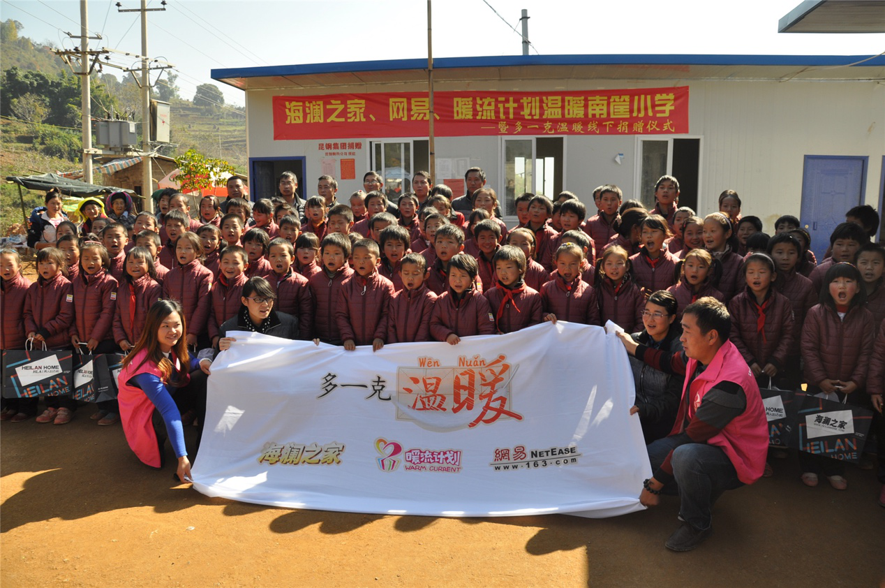 2014年11月20日，“多一克溫暖”公益團(tuán)隊(duì)來到8.3大地震的重災(zāi)區(qū)——云南省昭通市魯?shù)榭h的南筐小學(xué)。越過崎嶇山路，將一批又一批暖心羽絨服送到了師生們的手中，也將社會(huì)的關(guān)懷和愛意傳遞給了這些可愛的人。