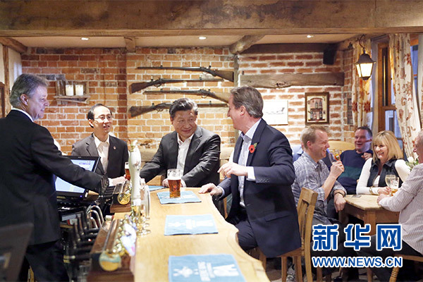 這是會晤結束后，習近平在卡梅倫陪同下乘車前往當?shù)匦℃?zhèn)體驗酒吧文化。新華社記者 鞠鵬 攝